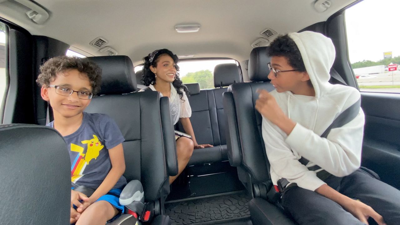 Pictured are Zenora, Soloman and Noah Collier riding in a vehicle with their mother, Teia Collier. (Spectrum News 1/Lupe Zapata)